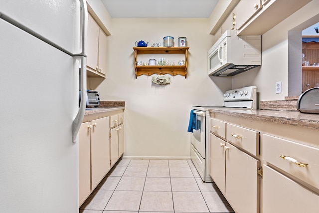 kitchen featuring white cabinets, light tile patterned flooring, and white appliances