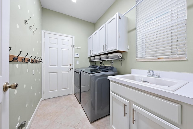 laundry area featuring cabinets, light tile patterned flooring, sink, and independent washer and dryer