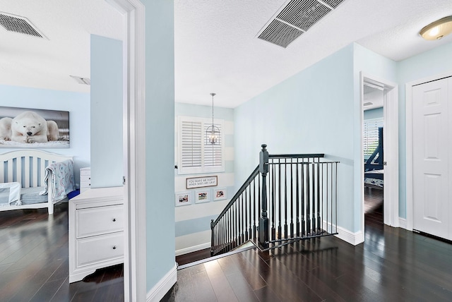 hall with dark hardwood / wood-style flooring and a notable chandelier