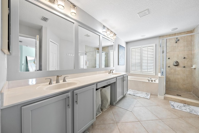 bathroom with vanity, shower with separate bathtub, tile patterned flooring, and a textured ceiling