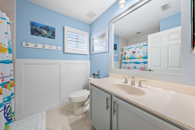 bathroom featuring tile patterned flooring, vanity, toilet, a textured ceiling, and a shower with shower curtain