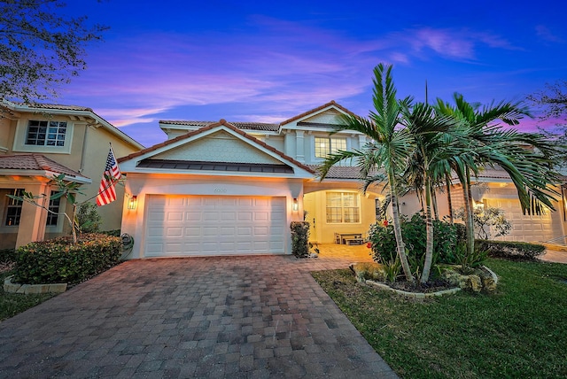 view of front of property featuring a garage and a lawn