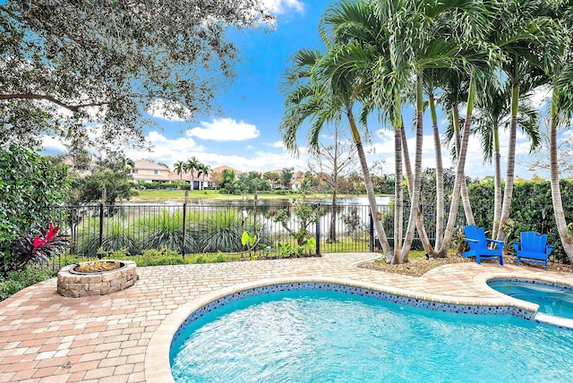 view of swimming pool with a water view, an in ground hot tub, and a patio area