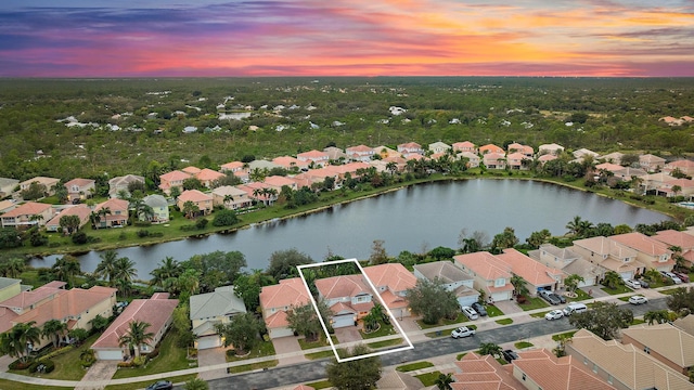 aerial view at dusk featuring a water view