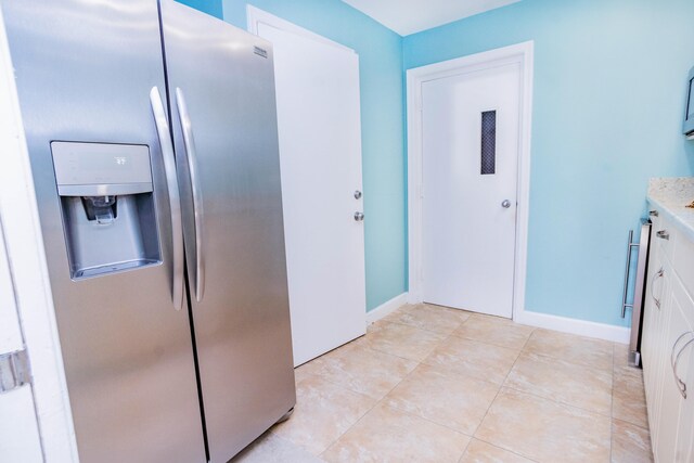 kitchen featuring white cabinetry, light tile patterned floors, and stainless steel refrigerator with ice dispenser