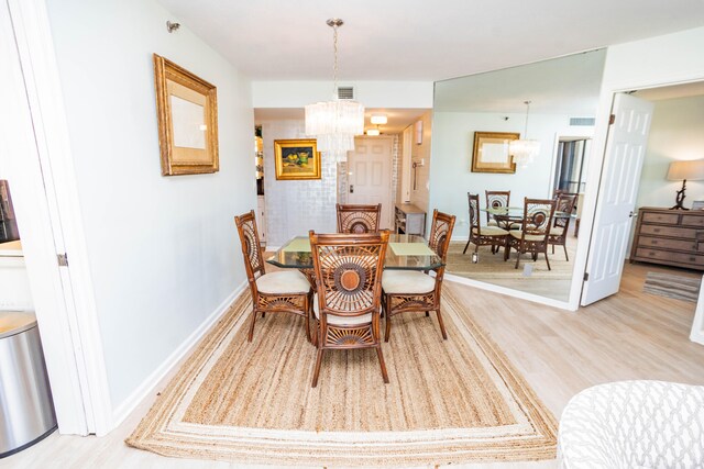 dining area with a chandelier and light wood-type flooring