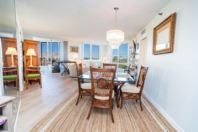 dining area with light hardwood / wood-style flooring and an inviting chandelier