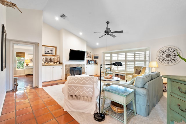 living room featuring a fireplace, tile patterned flooring, high vaulted ceiling, and ceiling fan