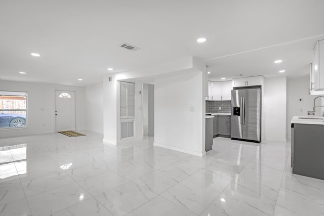 unfurnished living room featuring sink