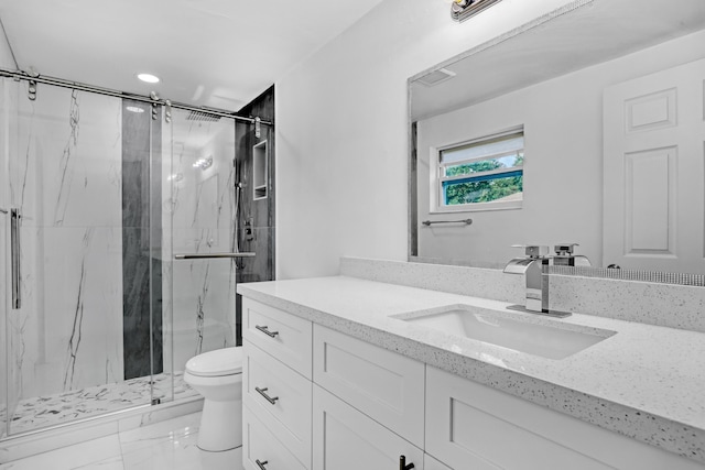 bathroom featuring a shower with door, vanity, and toilet