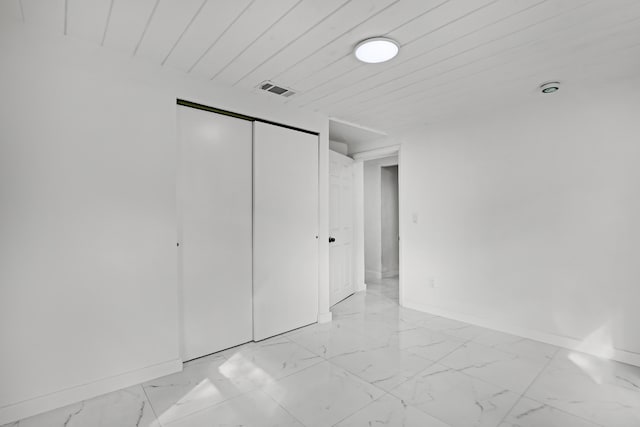 unfurnished bedroom featuring a closet and wooden ceiling