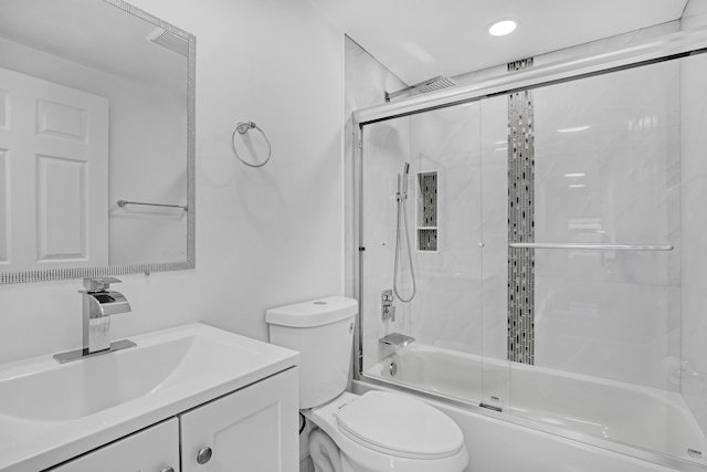 full bathroom with combined bath / shower with glass door, vanity, and toilet