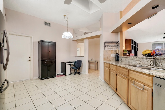 kitchen with light tile patterned flooring, sink, hanging light fixtures, light brown cabinets, and stainless steel appliances