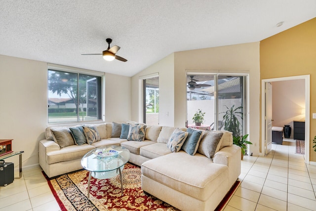 tiled living room featuring ceiling fan, lofted ceiling, and a textured ceiling