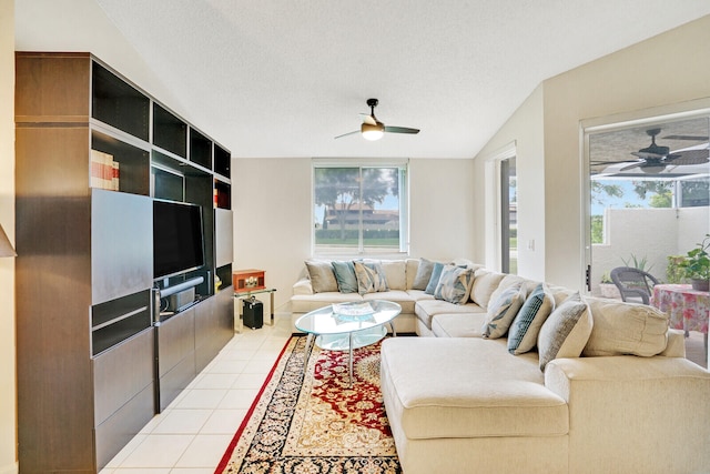 tiled living room with ceiling fan, a textured ceiling, and a wealth of natural light