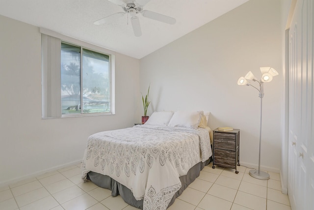 tiled bedroom featuring lofted ceiling and ceiling fan