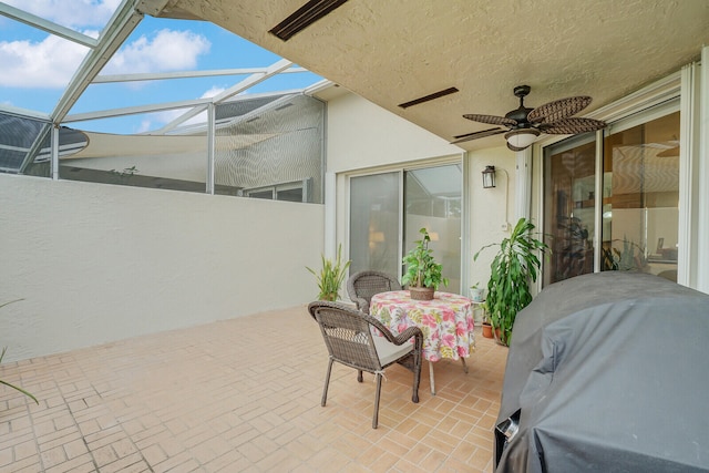 view of patio / terrace featuring ceiling fan, a grill, and glass enclosure