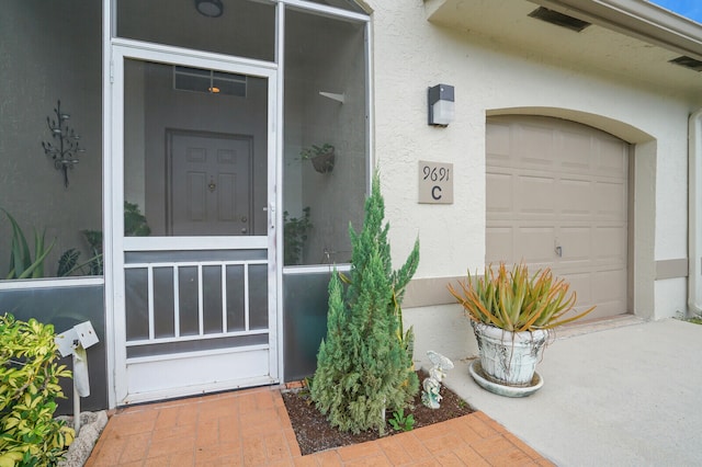 view of exterior entry with a garage