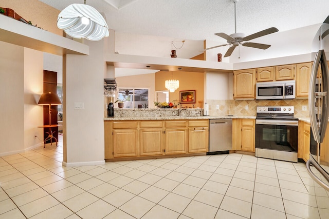 kitchen with light tile patterned flooring, appliances with stainless steel finishes, lofted ceiling, sink, and decorative backsplash