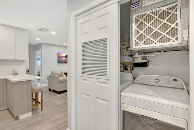 laundry room featuring washer and dryer and light wood-type flooring