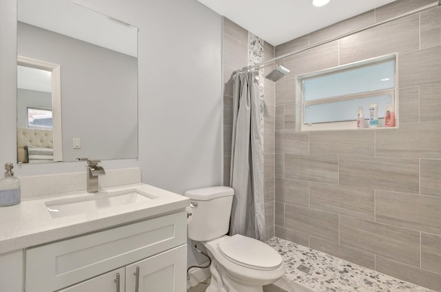 bathroom featuring walk in shower, vanity, and toilet