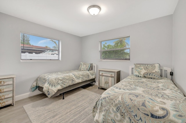 bedroom with multiple windows and light hardwood / wood-style floors