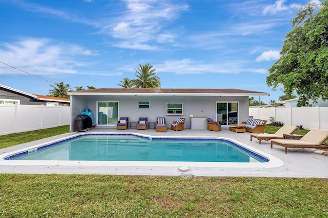 view of pool featuring outdoor lounge area, a patio, and a lawn