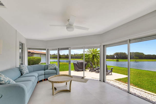 sunroom featuring ceiling fan, a water view, and visible vents