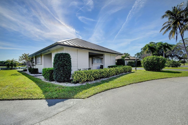 330 Cedar Key Cir, Atlantis, FL 33462 - view of side of home featuring a lawn, stucco siding, metal roof, and a standing seam roof