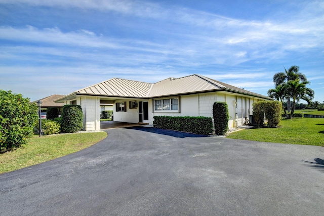 ranch-style home featuring a carport and a front yard