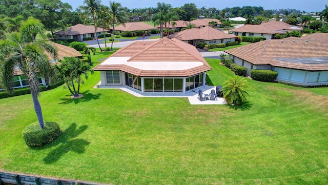 330 Cedar Key Cir, Atlantis, FL 33462 - back of property featuring a sunroom, a residential view, a yard, and a tile roof