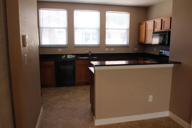 kitchen featuring kitchen peninsula, sink, a wealth of natural light, and black appliances