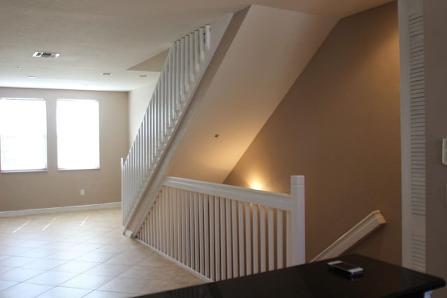 stairway with tile patterned floors