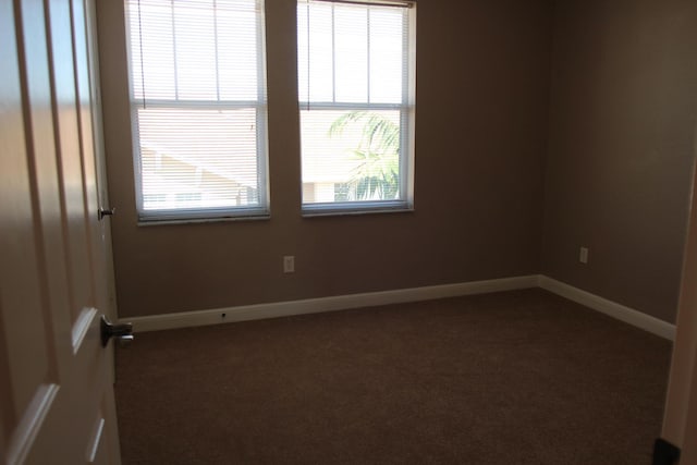 unfurnished room with dark colored carpet