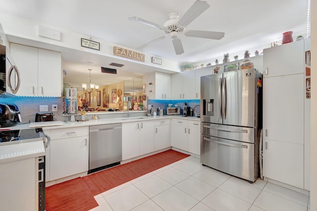 kitchen featuring ceiling fan with notable chandelier, white cabinetry, backsplash, and appliances with stainless steel finishes