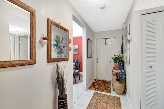 9668 Sills Dr Unit 101, Boynton Beach, FL 33437 - foyer entrance featuring light tile patterned floors, a textured ceiling, and baseboards