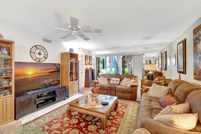 tiled living room featuring a textured ceiling and ceiling fan