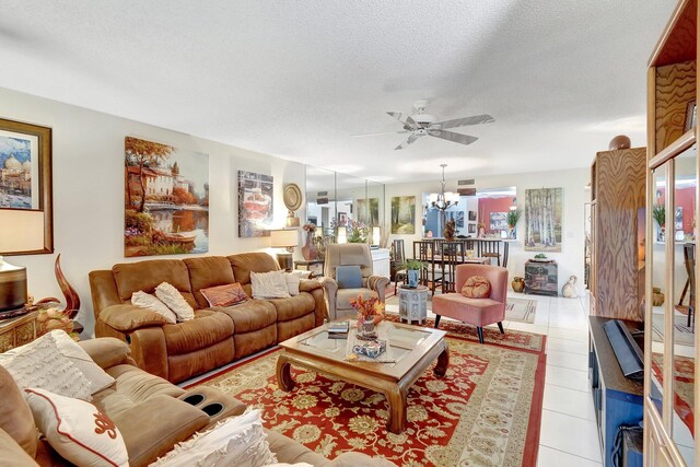 tiled dining room featuring ceiling fan with notable chandelier and a textured ceiling