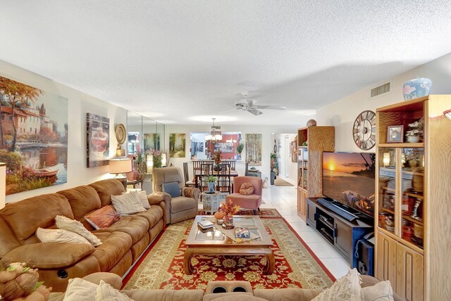 9668 Sills Dr Unit 101, Boynton Beach, FL 33437 - living area featuring a chandelier, light tile patterned floors, a textured ceiling, and a ceiling fan