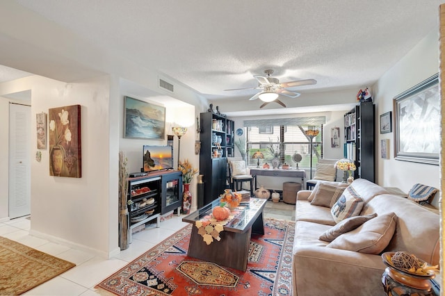 tiled living room featuring ceiling fan and a textured ceiling