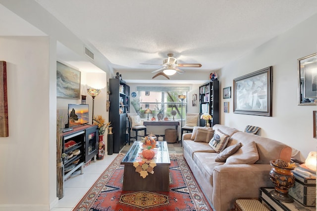 tiled living room featuring ceiling fan and a textured ceiling