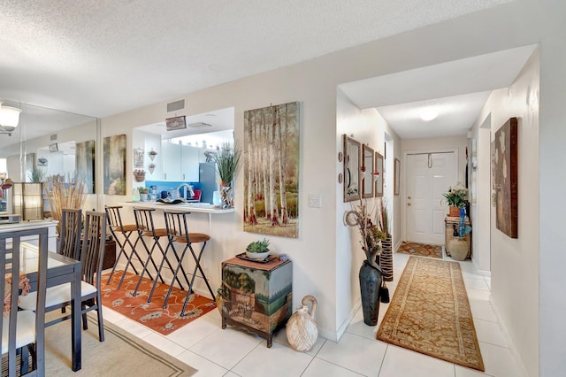 hallway featuring light tile patterned floors and a textured ceiling