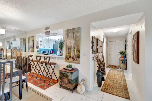 9668 Sills Dr Unit 101, Boynton Beach, FL 33437 - hallway with a textured ceiling, light tile patterned flooring, and baseboards