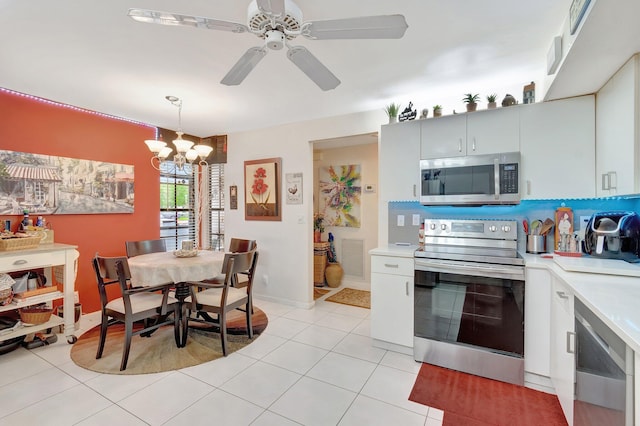 kitchen with ceiling fan with notable chandelier, light tile patterned floors, stainless steel appliances, and hanging light fixtures