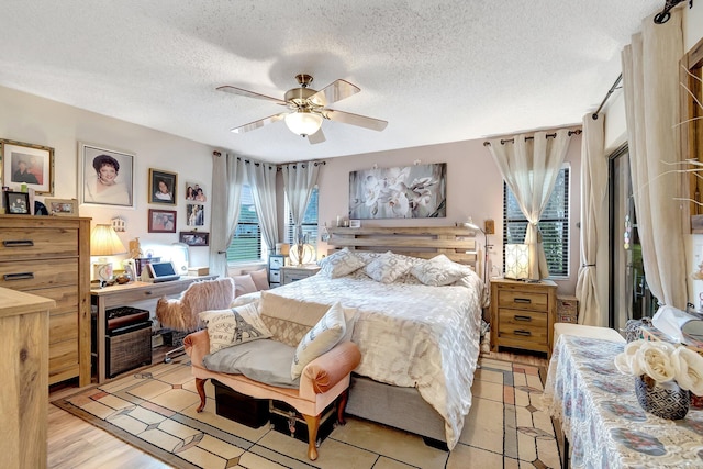 bedroom featuring a textured ceiling, light wood-type flooring, and ceiling fan