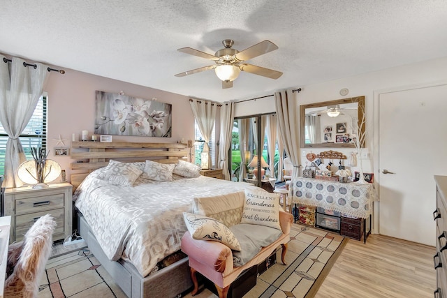 bedroom featuring a textured ceiling, light hardwood / wood-style flooring, multiple windows, and ceiling fan