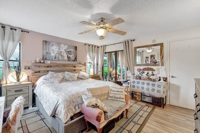 9668 Sills Dr Unit 101, Boynton Beach, FL 33437 - bedroom with multiple windows, a textured ceiling, light wood-style floors, and a ceiling fan