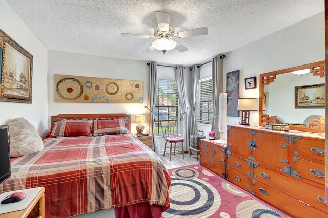 9668 Sills Dr Unit 101, Boynton Beach, FL 33437 - bedroom with a textured ceiling, access to outside, wood finished floors, and ceiling fan