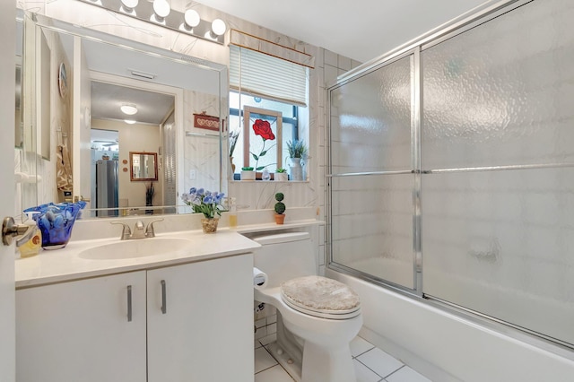 full bathroom featuring tile patterned floors, shower / bath combination with glass door, vanity, and toilet