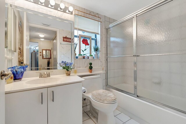 9668 Sills Dr Unit 101, Boynton Beach, FL 33437 - bathroom featuring tile patterned flooring, toilet, vanity, and combined bath / shower with glass door